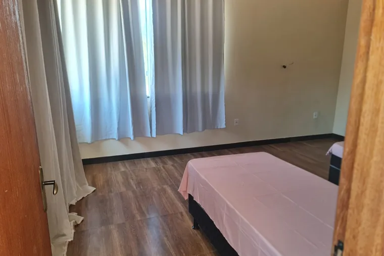 Cama com lençol rosa, janela aberta, em unidade de acolhimento da rede em Minas Gerais