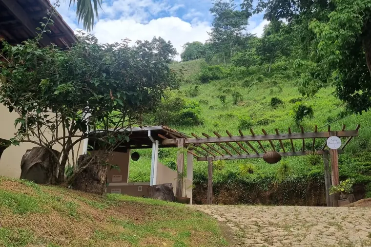 Entrada com vegetação e pedra, em unidade de acolhimento da rede em Minas Gerais