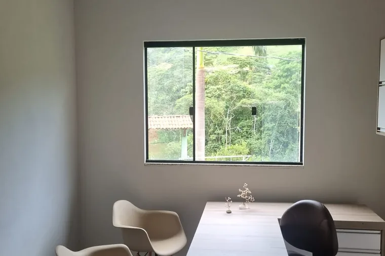 Mesa e cadeiras com janelas abertas, em unidade de acolhimento da rede em Minas Gerais