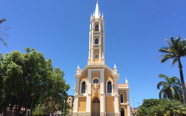Carmo do Cajuru - MG Igreja com torre e árvores ao redor em Carmo do Cajuru