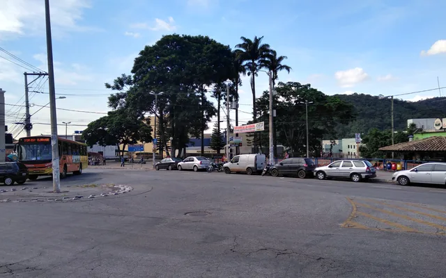 Ibirité - MG Rua com ônibus e árvores ao fundo em Ibirité